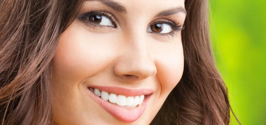 A woman smiles warmly revealing her white teeth