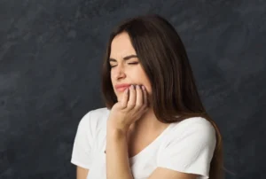 A woman holds her jaw in pain
