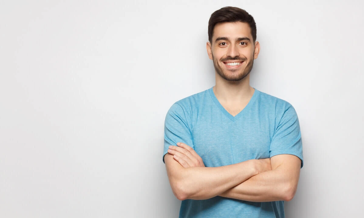 A smiling man with a confident, healthy smile representing the high value and long-term investment of the cost of teeth veneers for a complete smile transformation