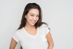 A young woman displaying the final results of her teeth veneers process, showcasing a bright, uniform smile that highlights the aesthetic improvements of cosmetic dental bonding.