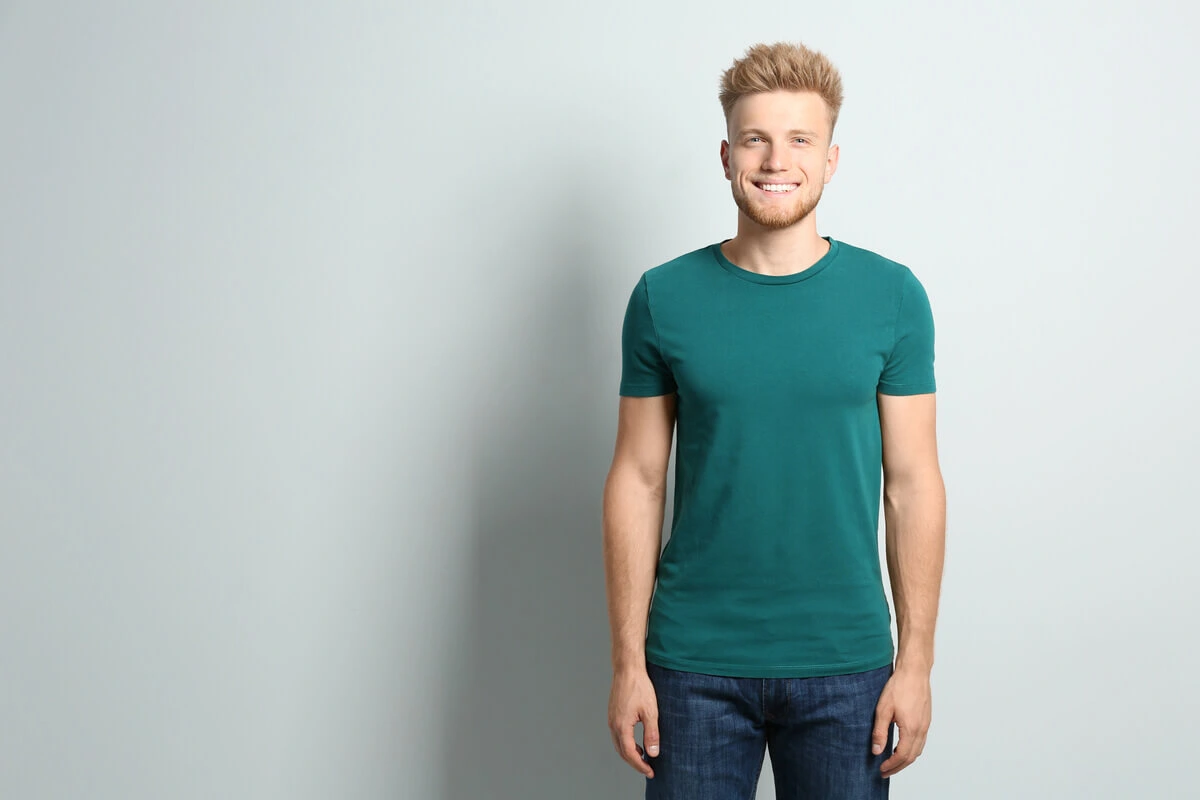 A young man showcasing a healthy, natural-looking smile, used to illustrate the facts behind whether veneers ruin your teeth and the importance of conservative tooth preparation for long-term oral health