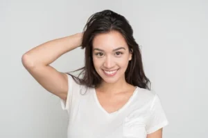 A smiling woman showcasing her final smile transformation after the teeth veneers process, highlighting the natural-looking and radiant results of professional cosmetic dentistry
