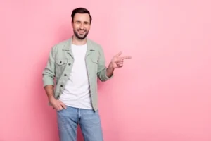 A smiling man points toward information on dental treatment solutions for cracked teeth, exuding a relaxed vibe that reflects a successful restoration and a pain-free smile.