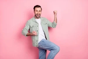 A man celebrating with raised fists and a wide smile, expressing the relief and excitement of successfully fixing a cracked tooth with a permanent restorative treatment.