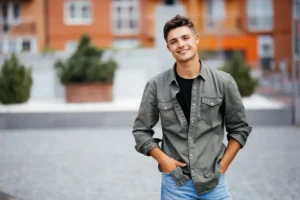 A young man looking relaxed and well-rested outdoors, demonstrating the positive outcome of learning how to sleep with a toothache using professional dental advice and effective pain management