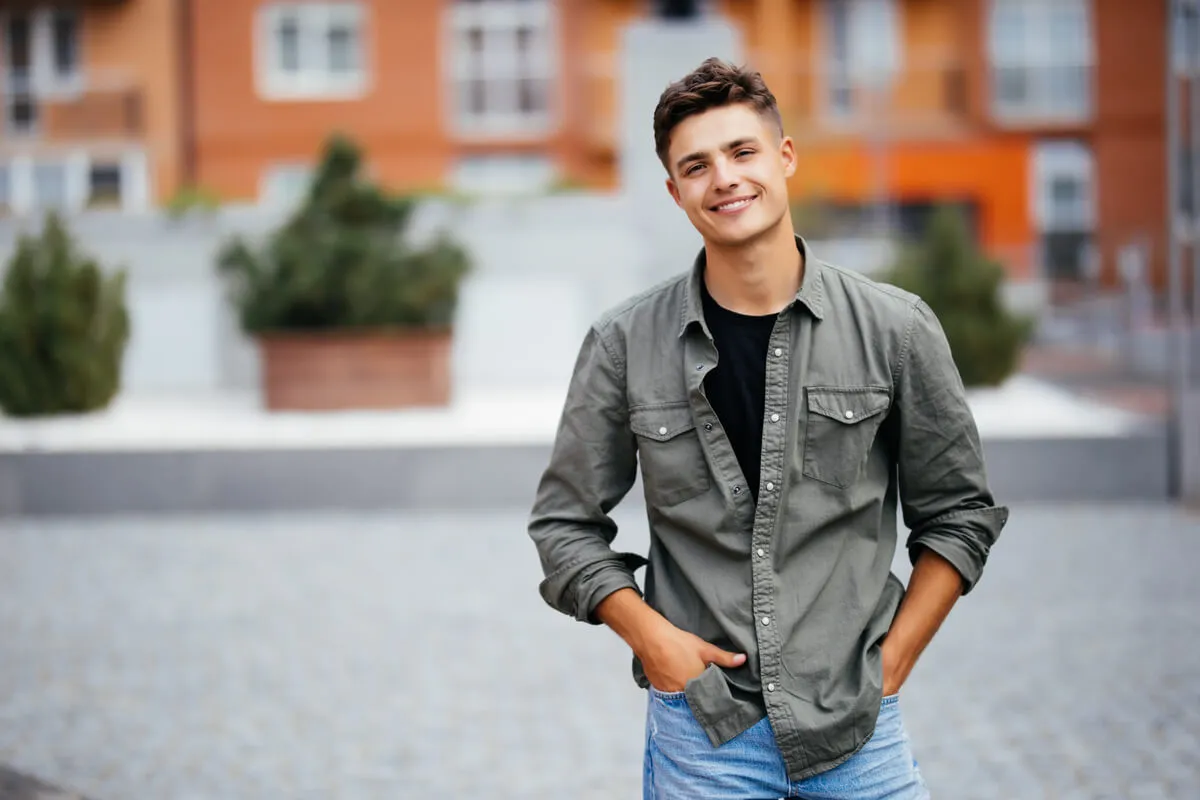 A young man looking relaxed and well-rested outdoors, demonstrating the positive outcome of learning how to sleep with a toothache using professional dental advice and effective pain management