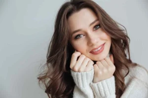 A woman smiling warmly with a sense of comfort and approachability, representing the lasting relief and confidence regained after successful treatment for severe tooth pain.