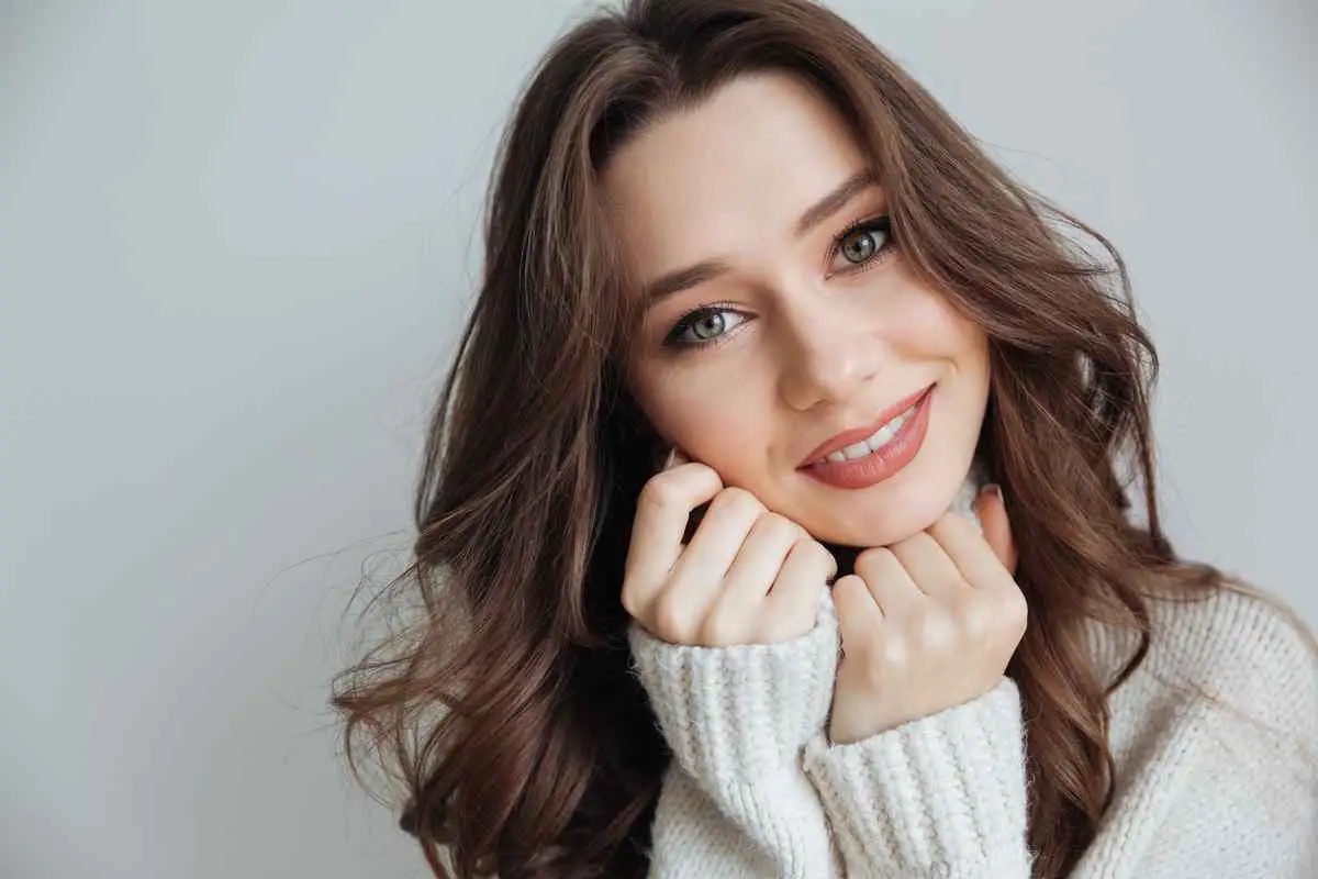 A woman smiling warmly with a sense of comfort and approachability, representing the lasting relief and confidence regained after successful treatment for severe tooth pain.