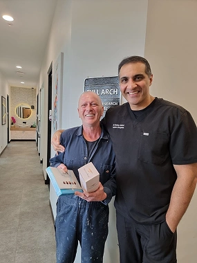 Patient who is holding gift boxes with Dr Sehmi