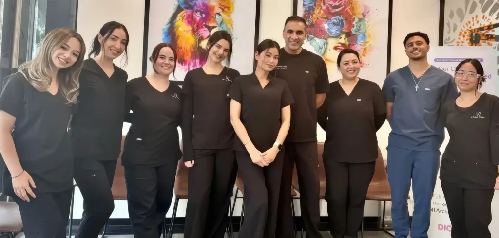 Finesse Dental Staff smiling and standing together in a room