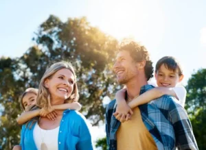 A joyful family of four posing outdoors, creating a warm and cheerful atmosphere