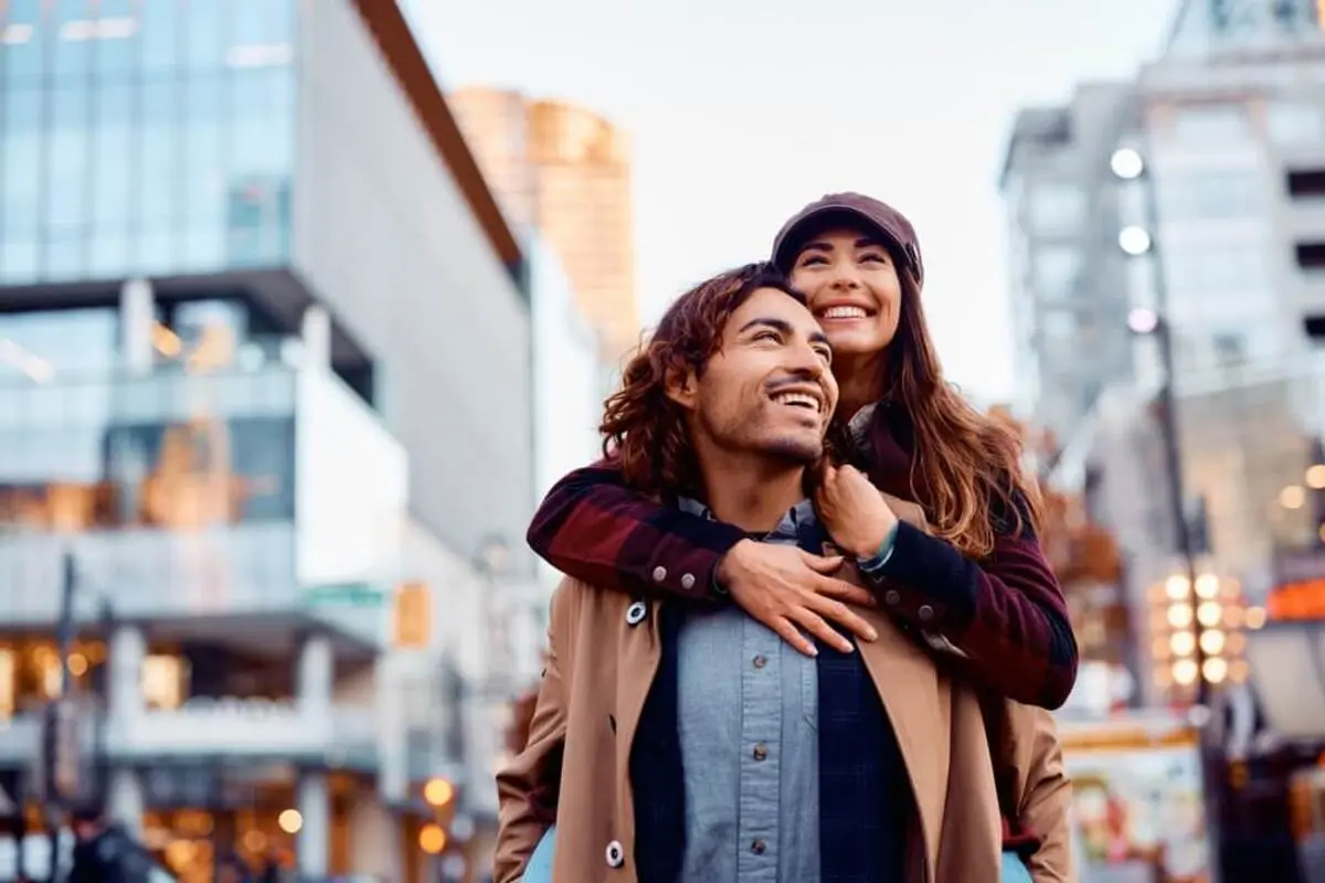 A happy couple sharing a confident smile while embracing in the city