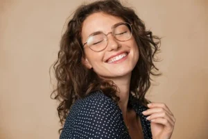 A woman smiling joyfully with closed eyes, expressing the profound relief and comfort found after receiving emergency dental care for broken tooth pain.