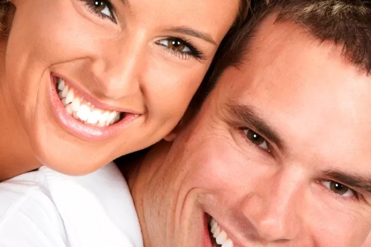A smiling couple showcasing healthy, natural-looking smiles restored with ceramic crowns, highlighting the durability and aesthetic appeal of modern restorative dentistry.