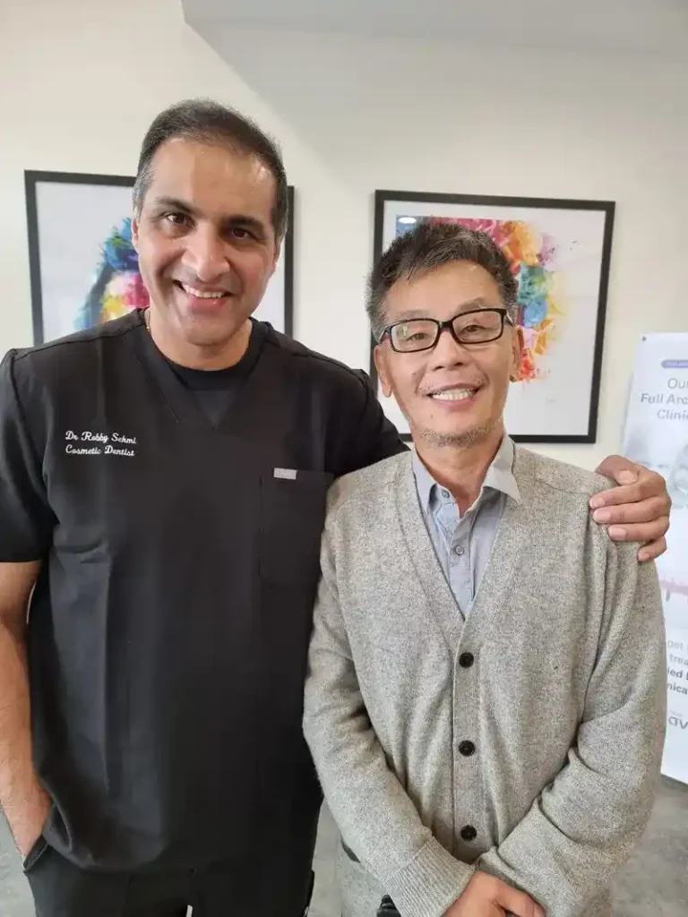 Dr. Sehmi standing alongside a happy patient in the Finesse Dental office, celebrating a successful treatment outcome and a newly restored smile.