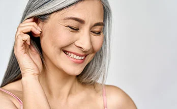 Elderly women closed eyes while touching her ear