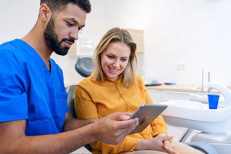 A healthcare staff member explaining something to a woman using items on a table