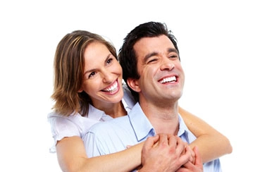 A happy couple holds each other closely both smiling