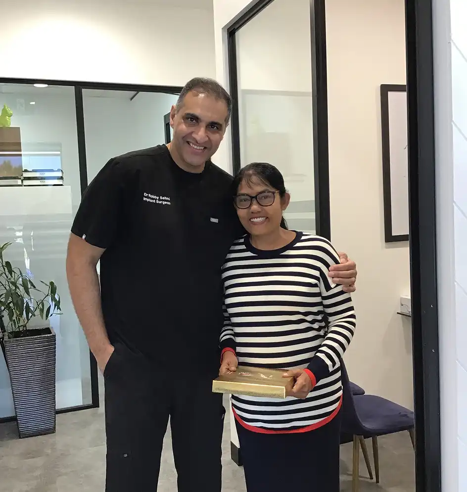 Dr Robby with the female client holding a gift