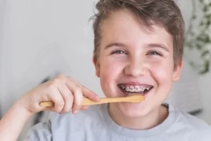 little boy with braces brushing teeth little boy with braces brushing teeth