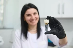 dentist showing a dental implant sample set dentist showing a dental implant sample set